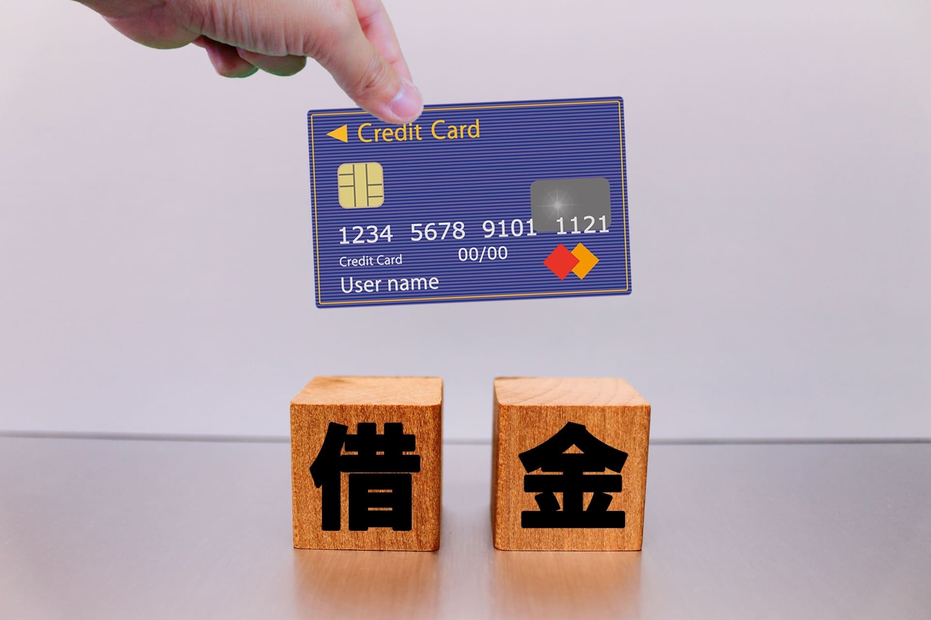クレジットカードと借金と書かれた木のブロック